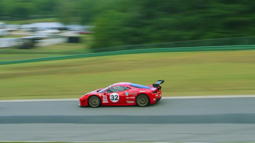 Aerial view of colorful race cars competing on a race in a race track at daytime