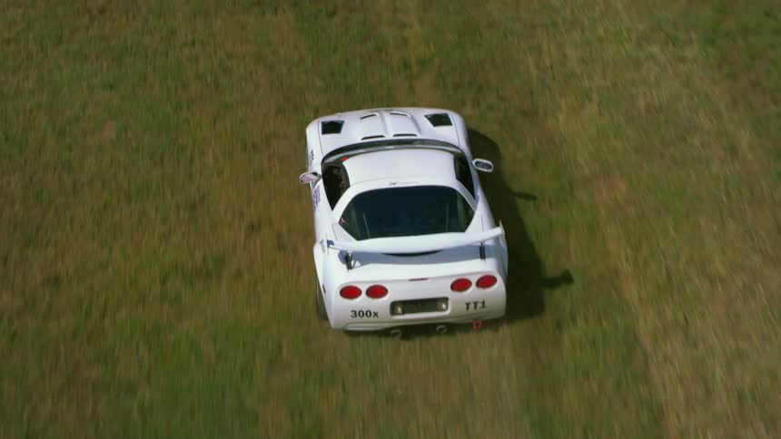 Race car skids off of the track into a field then gets back on the track to continue the race
