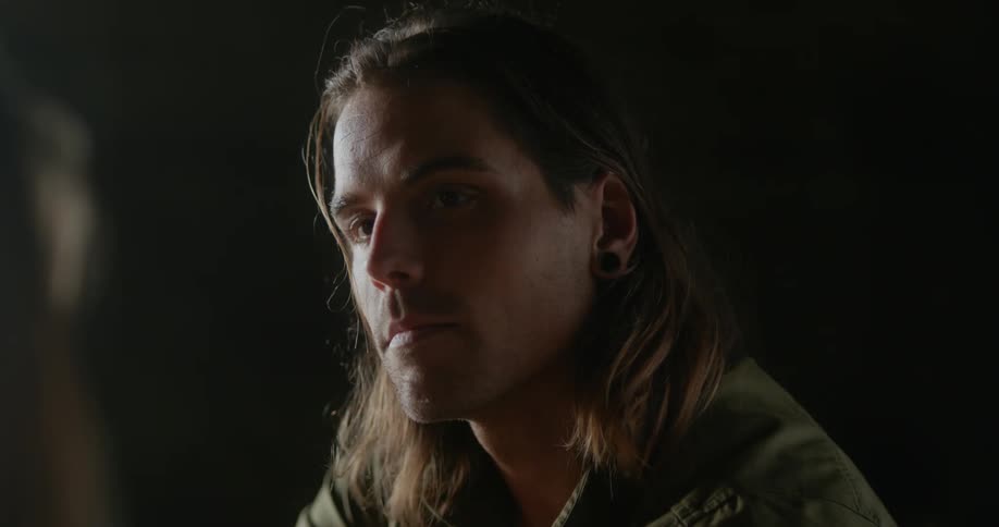 Man turns to face another person focusing closer on their face