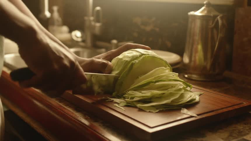 A man cuts cubbage into wide but thin slices