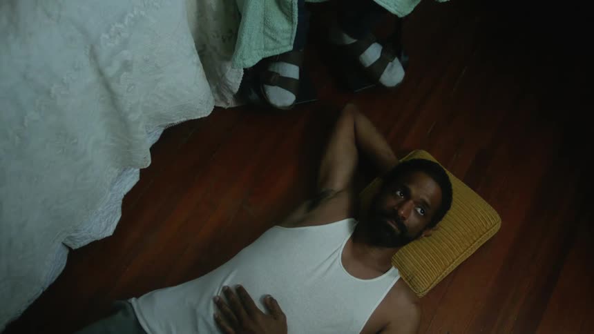 A man in a room laying on the floor next to a person in a wheelchair