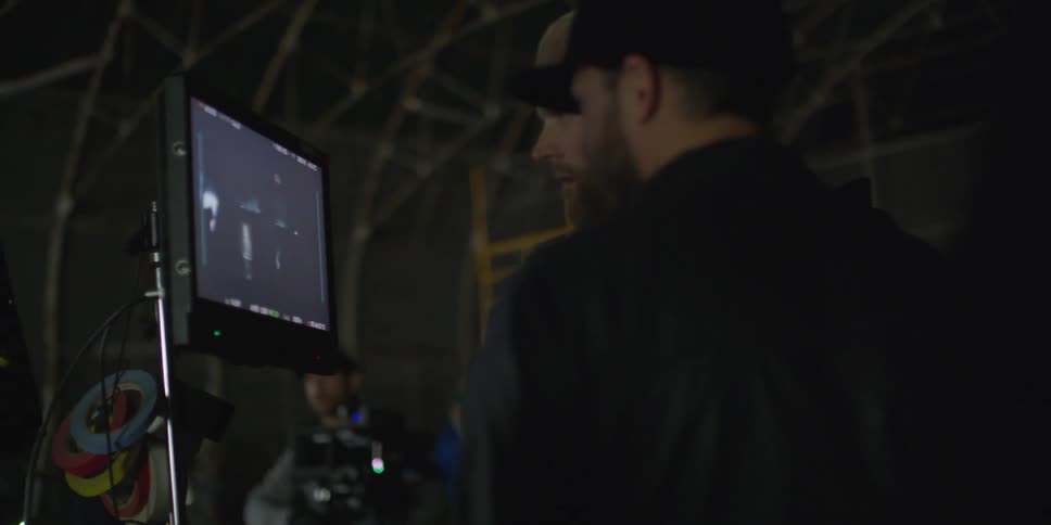 Men watching video footage on a monitor on set