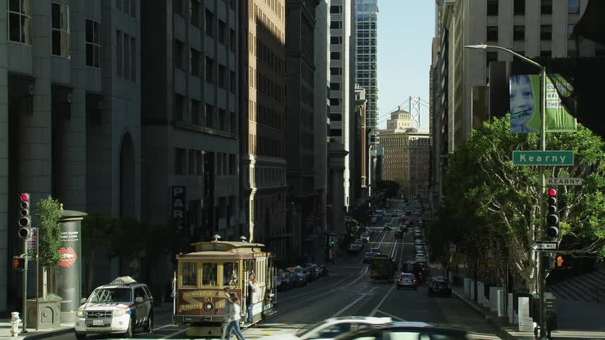 A cable car idles at an busy intersection in downtown san francisco