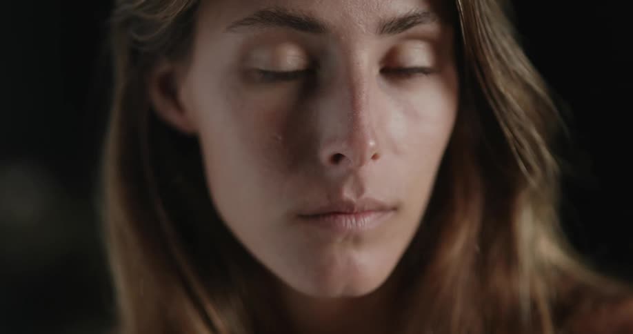 A woman is staring around blinking