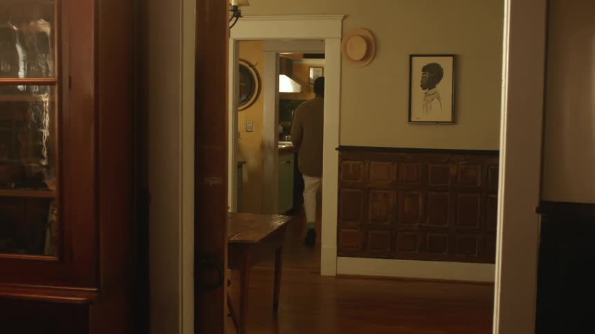 Man carries a paper bag with groceries into the kitchen at home