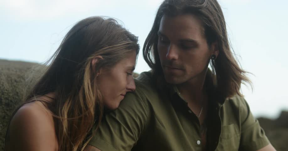 A woman leaning on a man outdoors