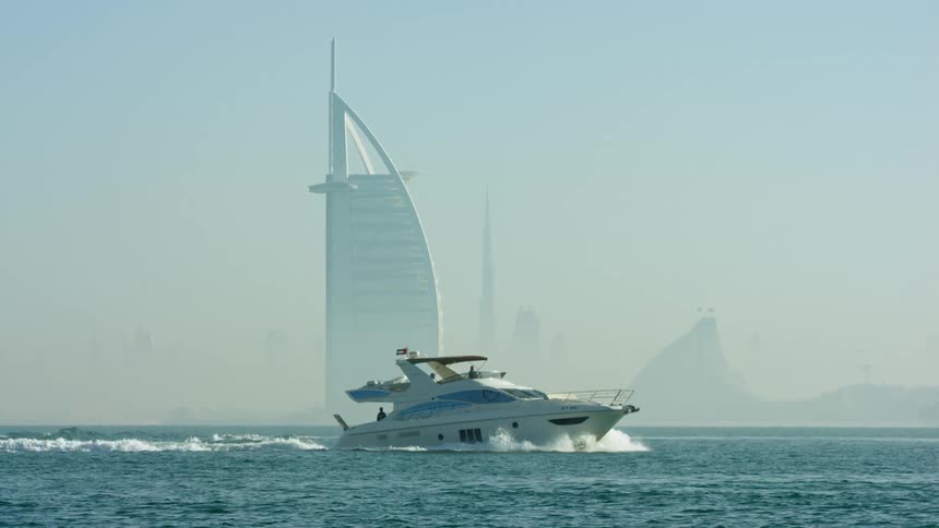 A yacht travels past the luxury hotel burj al arab