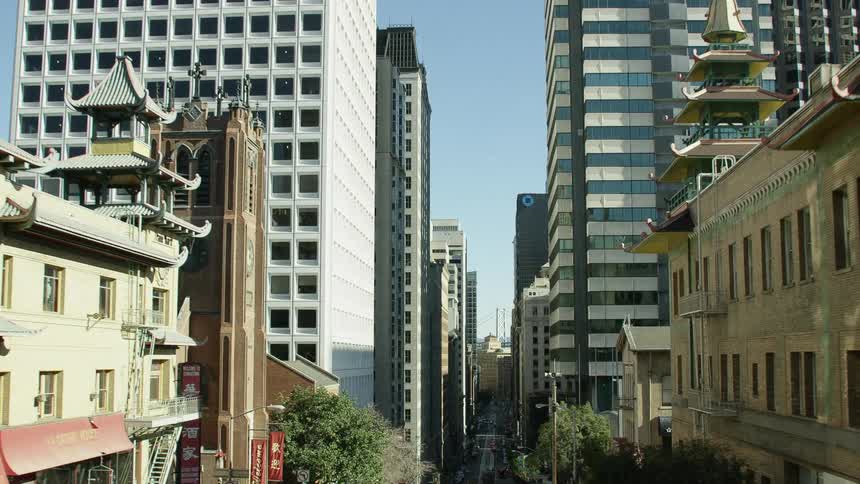 An aerial view of high rise office buildings and cars driving in a downtown area