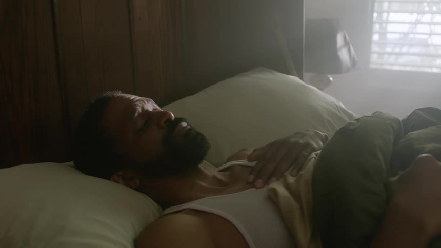 Man lying in bed wakes and have way sits up looking