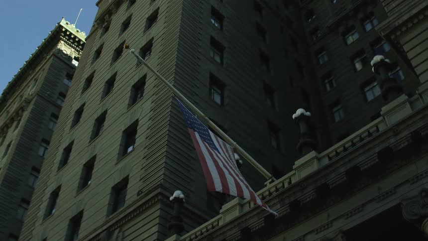 An american flag is hanging from a tall building