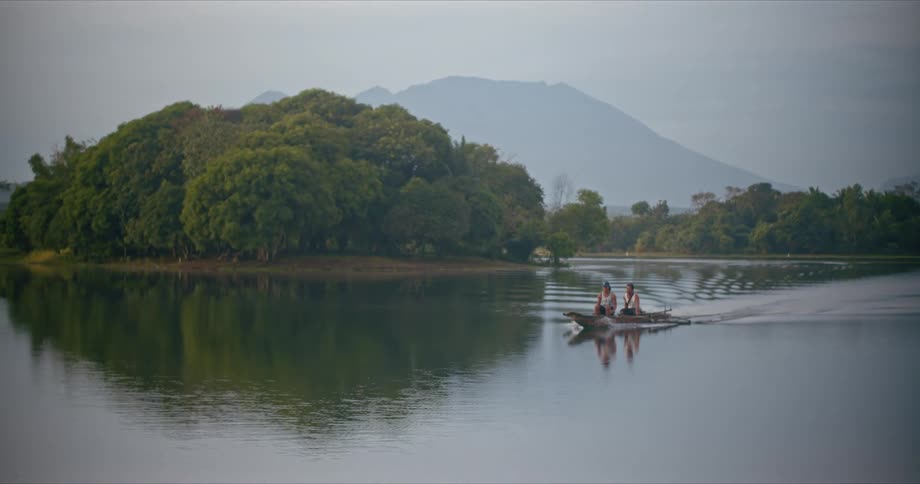 A man and woman make their way across a lake in a boat