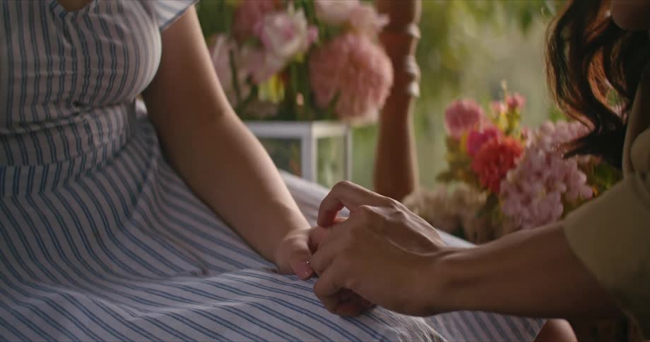One woman is comforting another woman as they sit outside