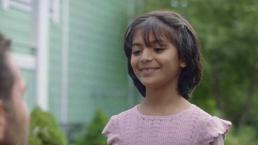 An excited child giving a thumbs up to her father