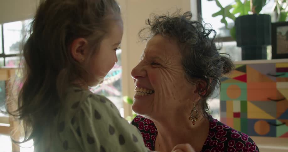 A grandmother and granddaughter hugging in a room