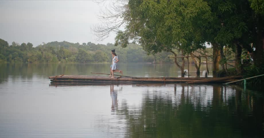 A man and woman run to the end of a pier at a rural lake