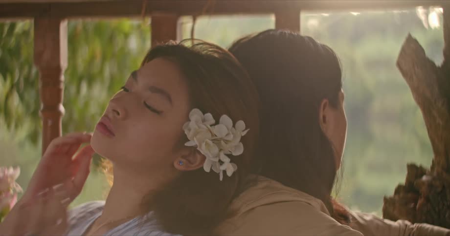 A woman putting a flower in her hair
