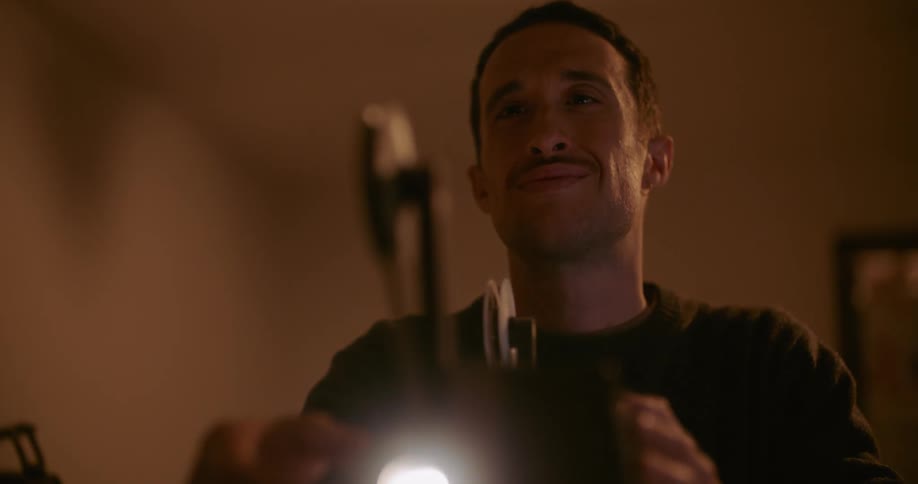 A man is smiling while playing a vintage film projector