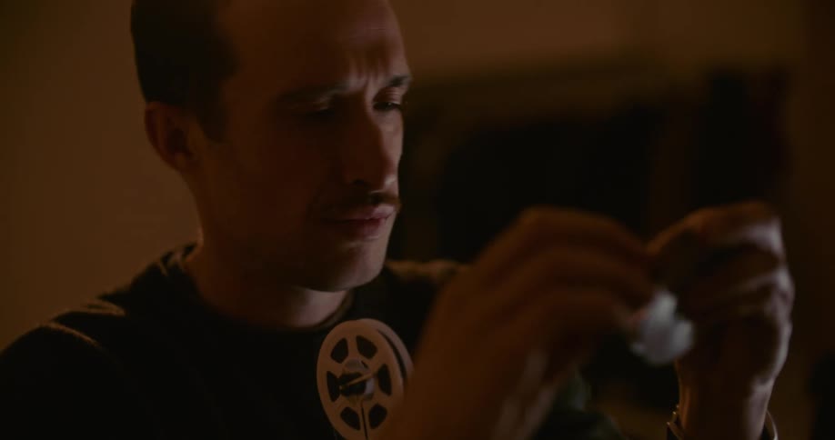 Man with black t shirt makes movie reel