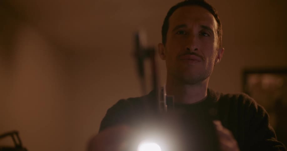 Man with black sweater watches through old movie projector