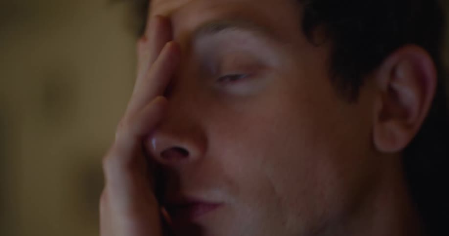Sleepy man types on laptop feeling tired