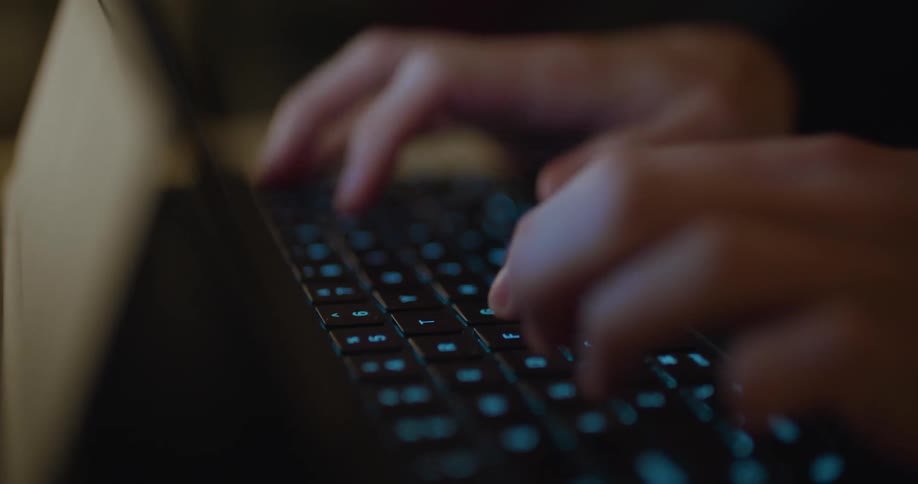 A person typing on a laptop keyboard