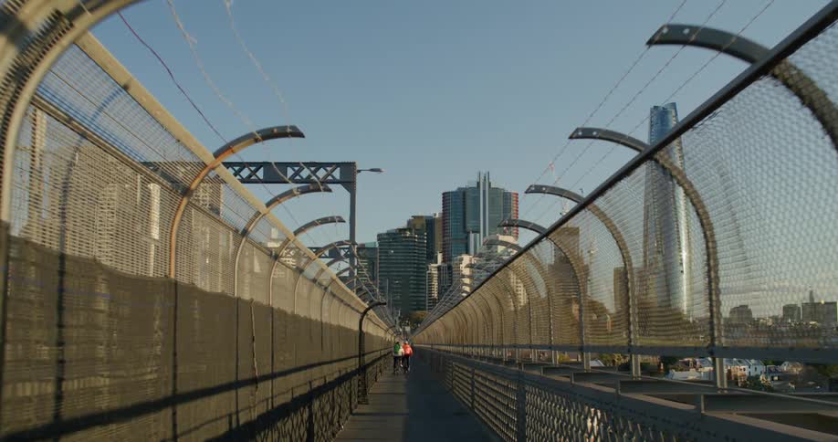 A group of people walking across a bridge