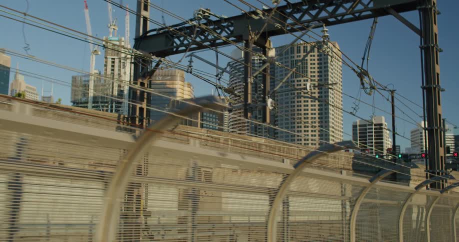 City apartments seen from moving train against the blue sky