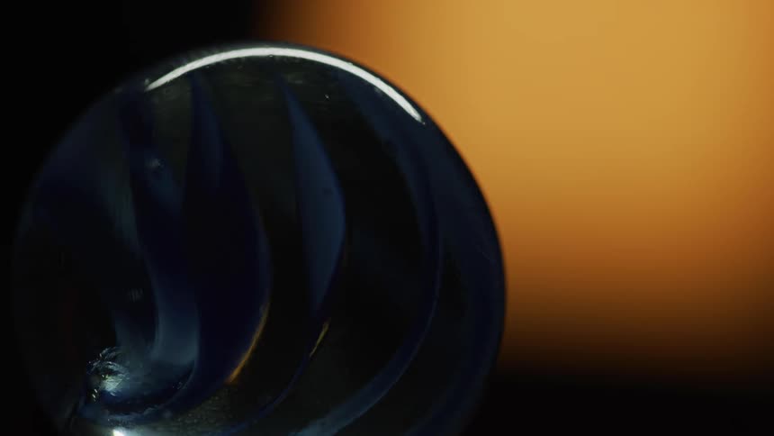 A yellow light traces the outside of a blue marble