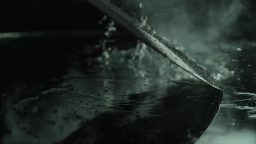 Water pours down on a record album spinning on its edge as a puddle forms