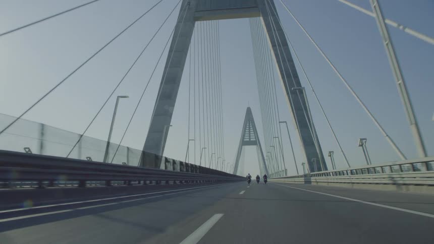 Bikers ride motorcycles crossing the suspension bridge
