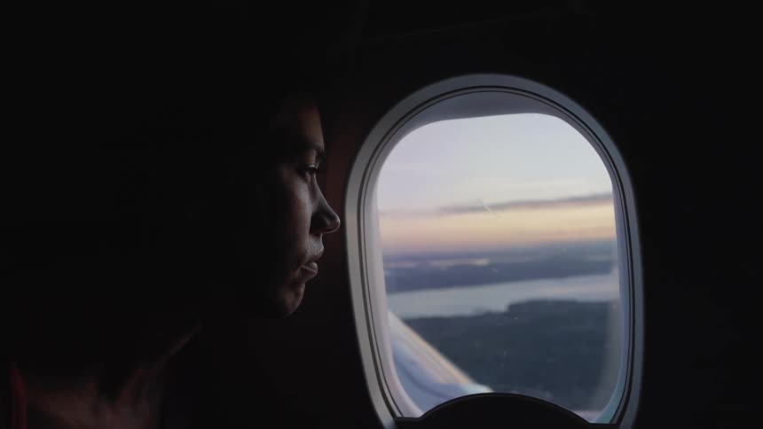 A woman looking out of a plane window