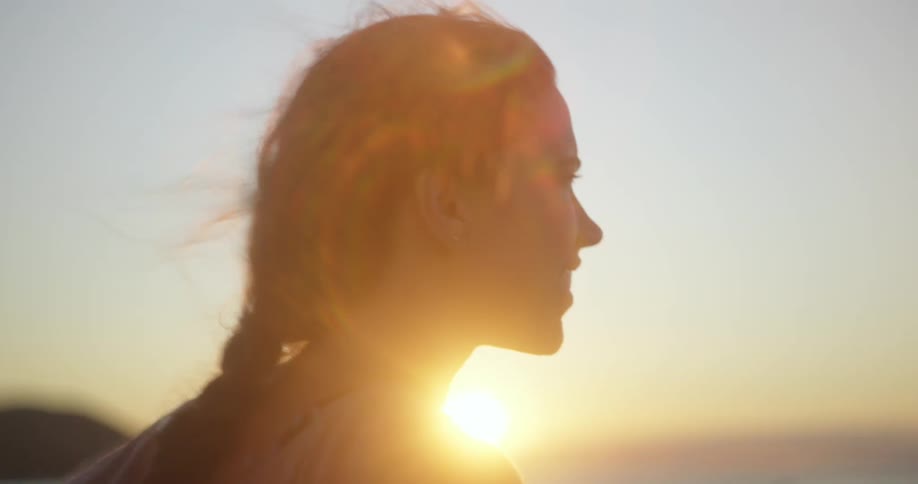 A girl watches the sunrise on the beach
