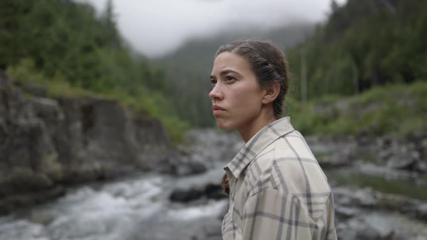 A native woman crosses the stream in the wilderness