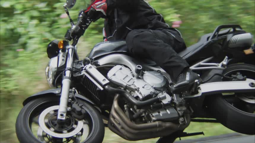 A motorcyclist rides around a curve in the road