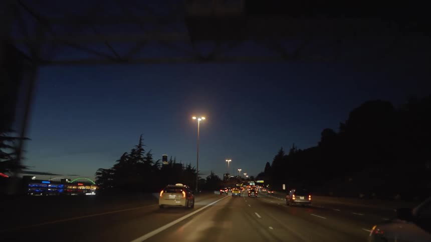 Cars and a cab travel on a highway at night
