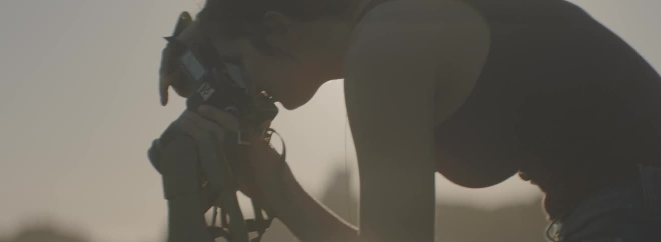 A woman leans forward taking a photograph