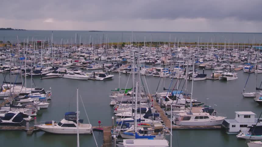 Aerial view of boats and ships parked at a harbor is displayed