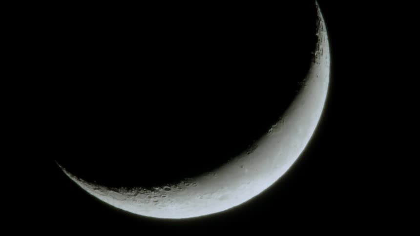 A crescent moon in a black sky