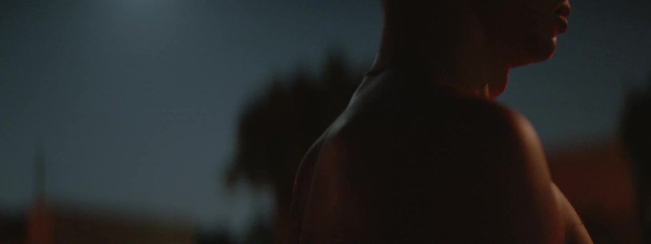 A young man stands bare chested under the moonlight