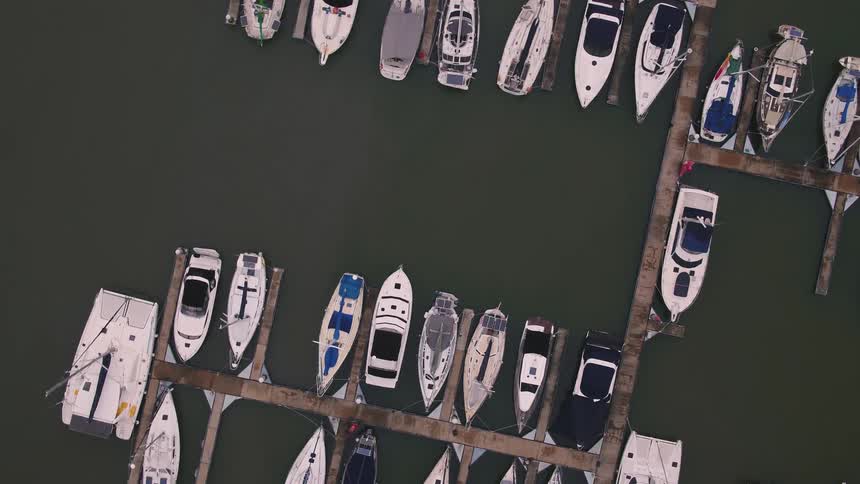 Several boats docked at a marina on smooth water