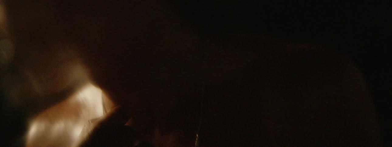 A shirtless man is biting at his finger and then spitting