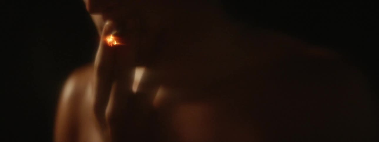 A man lifts a cigarette to smoke it