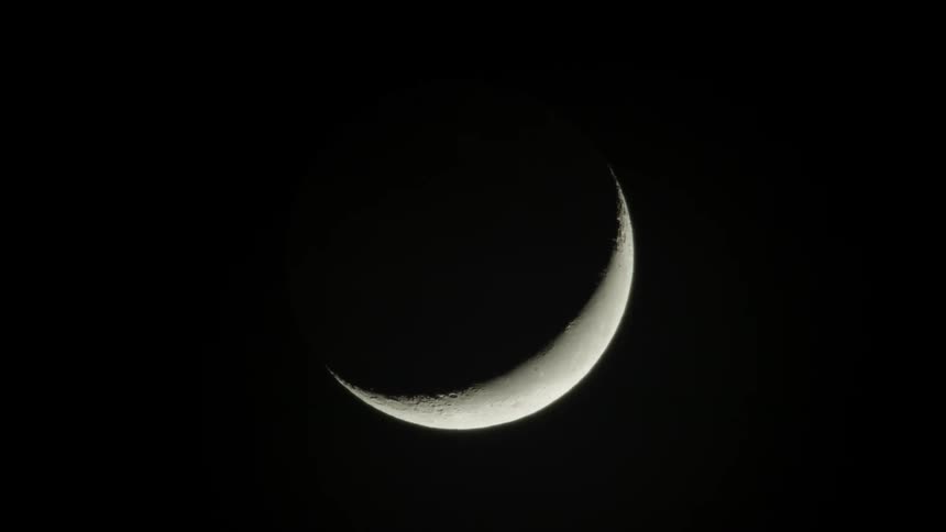 A crescent moon in a black sky