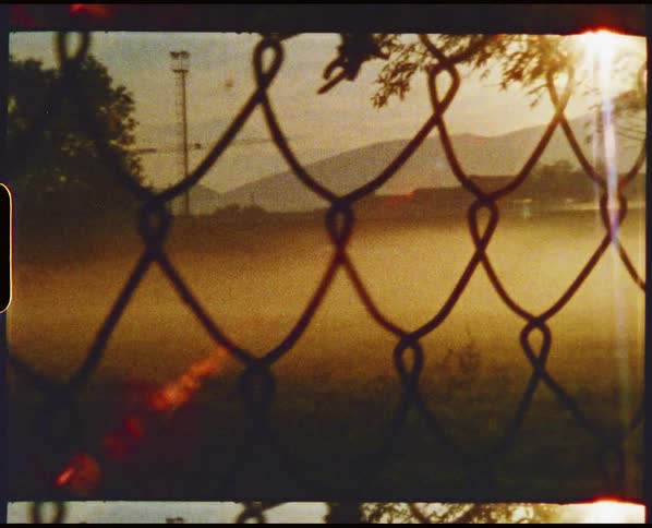 Fog covers the field behind the fence