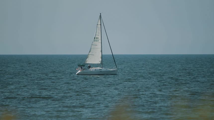 People are sailing on a sailboat on choppy ocean water