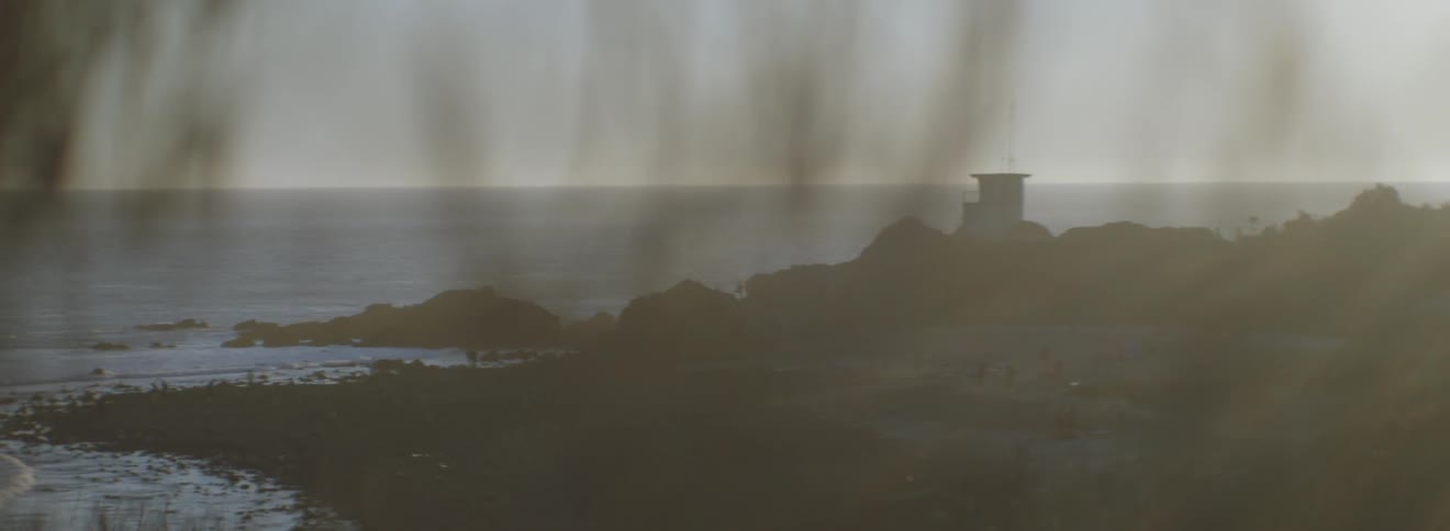 A light tower sits near the shore