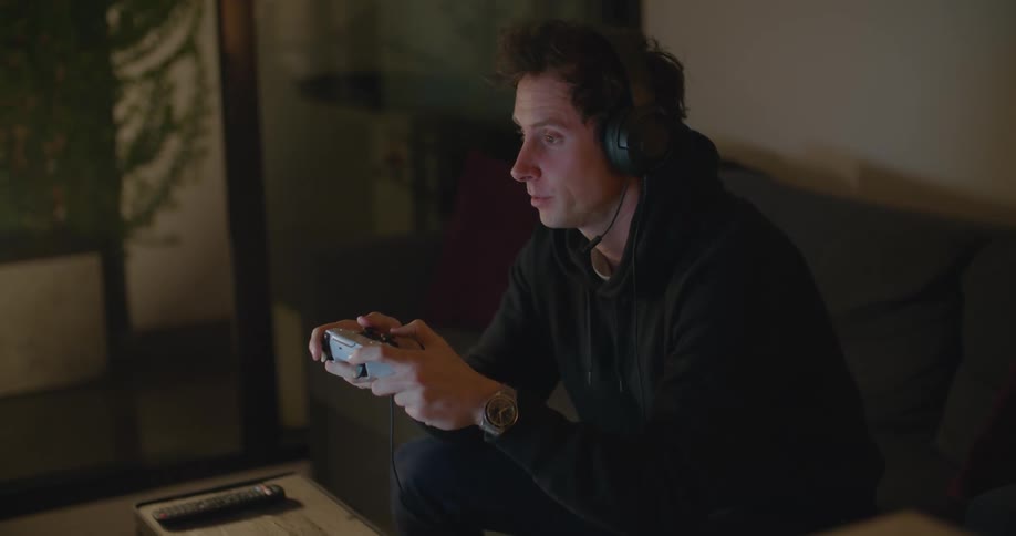 A man rubs his eyes while playing a video game