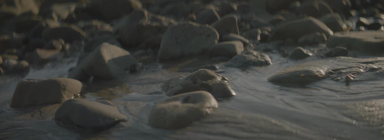 Rocks sit in the sand near a beach