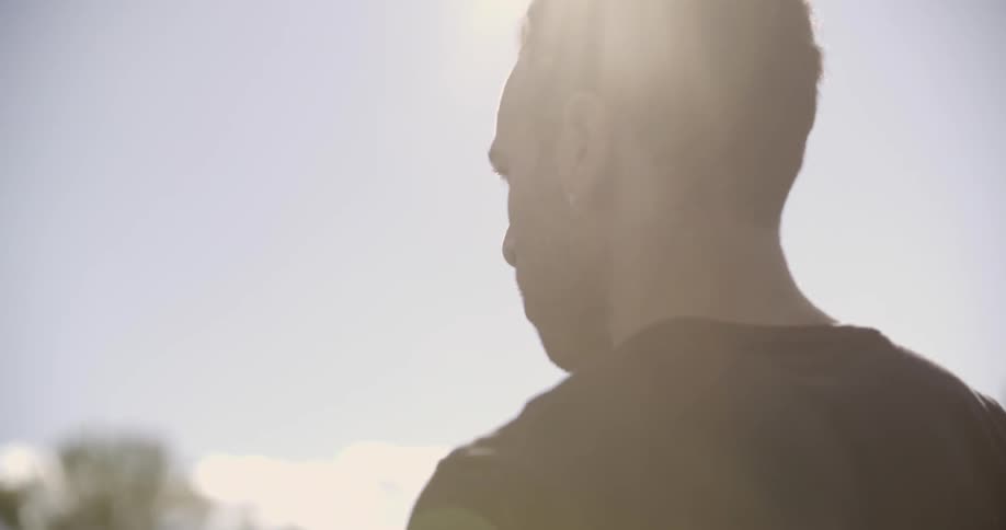 A man is walking outside on a sunny day