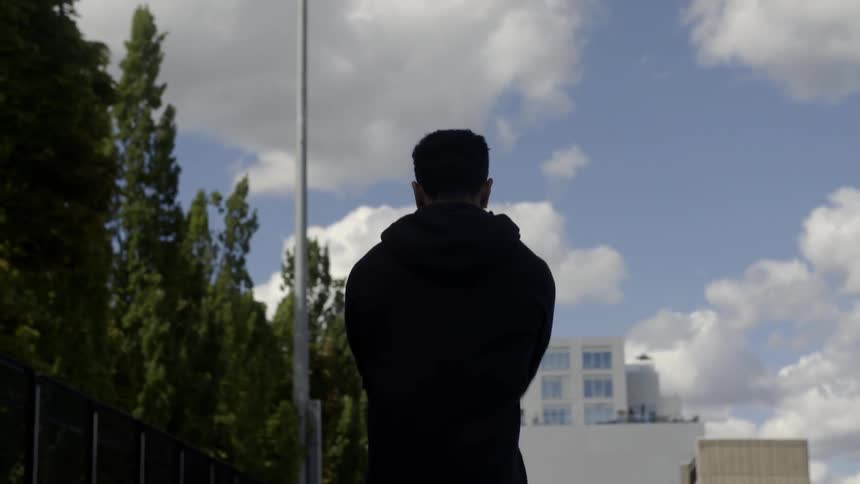 A man stretches his arms as he walks